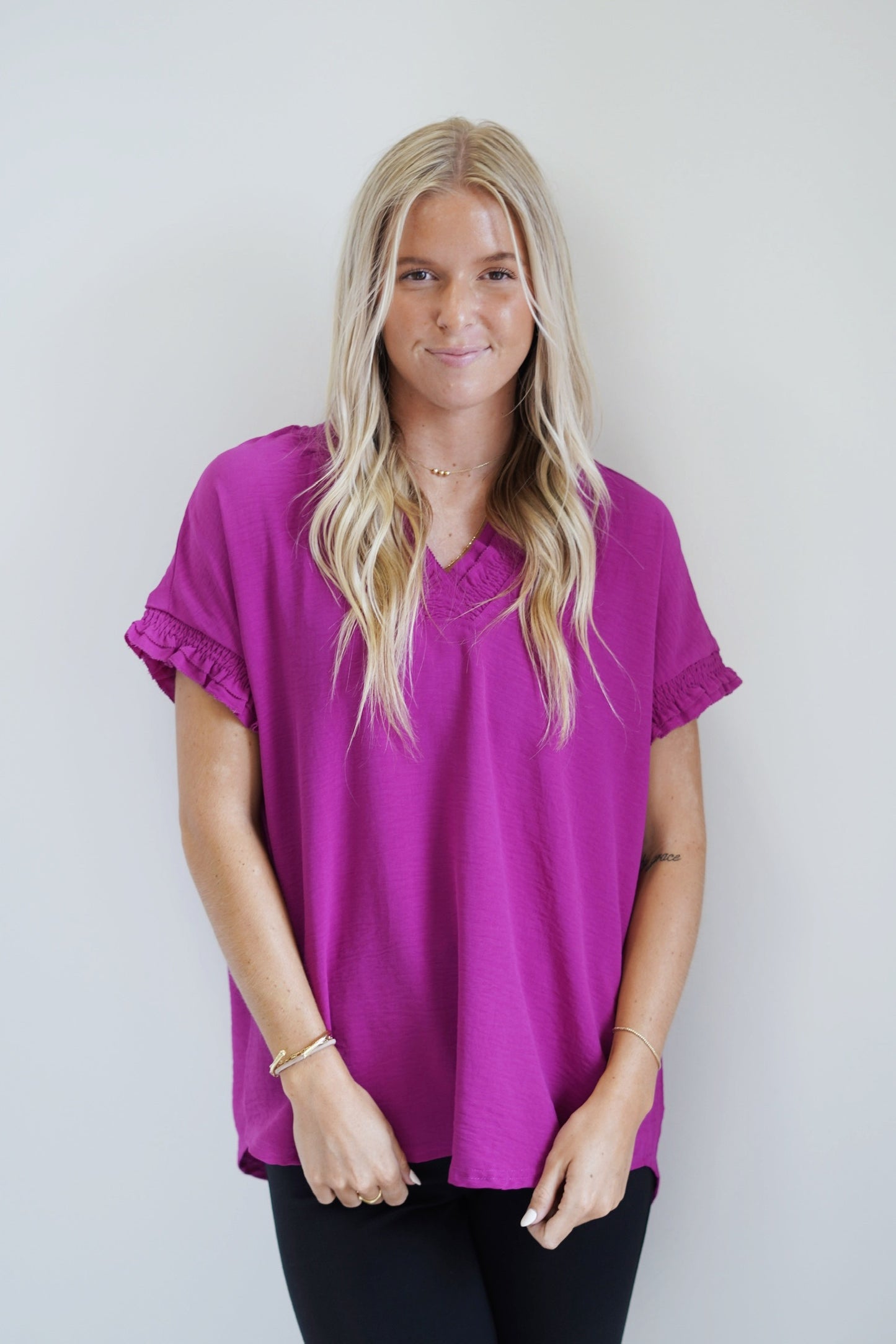 Sully Smocked Neckline Blouse Smocked V-Neckline Short Sleeve Smocked and raw hem detail on the neckline and sleeve cuffs Magenta Color Full Length Loose Fit 100% Polyester