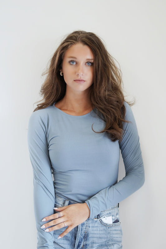 This Raven Round neck Long Sleeve BodySuit is so comfortable and cute! Paired with wide leg jeans and sneakers, this would make for the most gorgeous outfit! The butter soft material makes this body suit even better! Raven Round Neck Long Sleeve BodySuit Round Neckline Long Sleeves BodySuit. Button closures Butter Soft Material Color/ Chambray 84% Poly Microfiber, 16% Polyester Wash With Like Colors Model is wearing size small