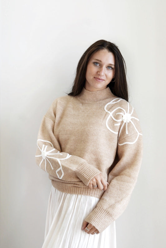 Fray Flower Embroidery Mock Neck Sweater Mock Neckline Long Cuffed Sleeves White Flower Embroidery Detail Taupe Color Cuffed Ribbed Hem Relaxed Fit 54% Polyester, 30% Acrylic, 16% Nylon