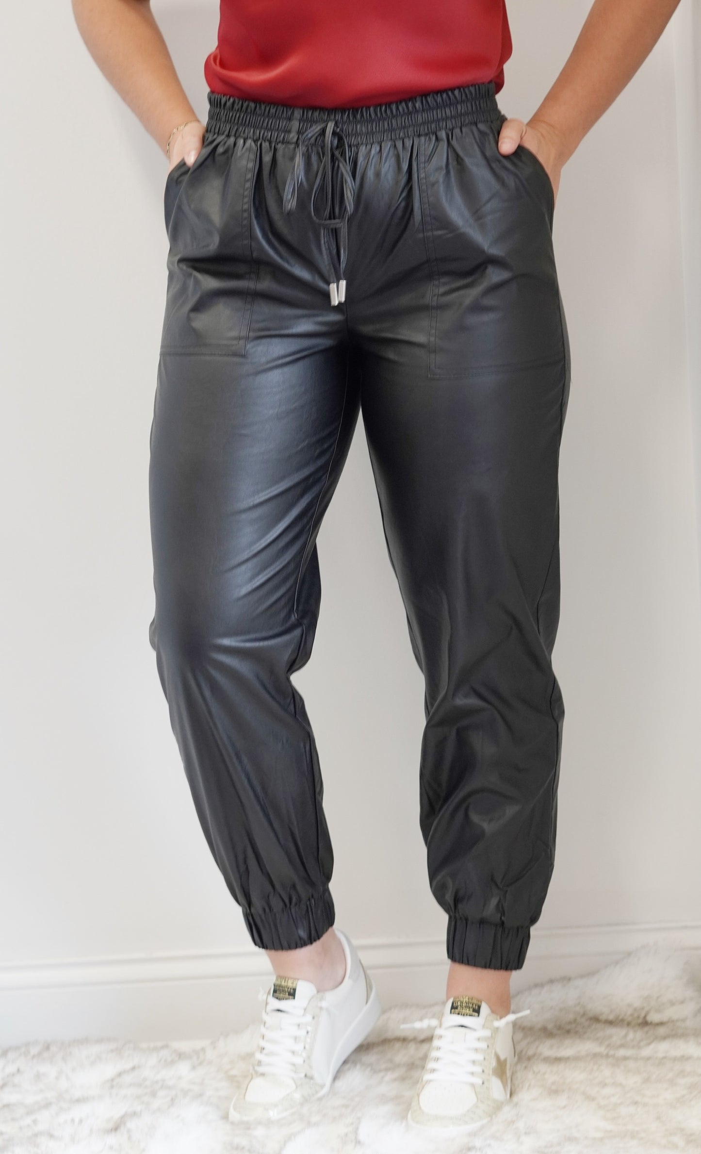 Lola Faux Leather Jogger Pants Smocked Elastic Tie Waistband Jogger Legs Front Pockets Black Faux Leather Jogger Fit 55% Cotton, 45% PU