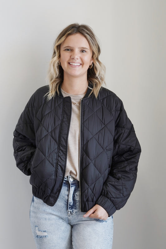 Reversible Nylon Bomber Jacket Zipper Ribbed Collar Reversible: Sleek Side, Quilted Side Color: Black Pockets Long Cinched Sleeves 100% Nylon