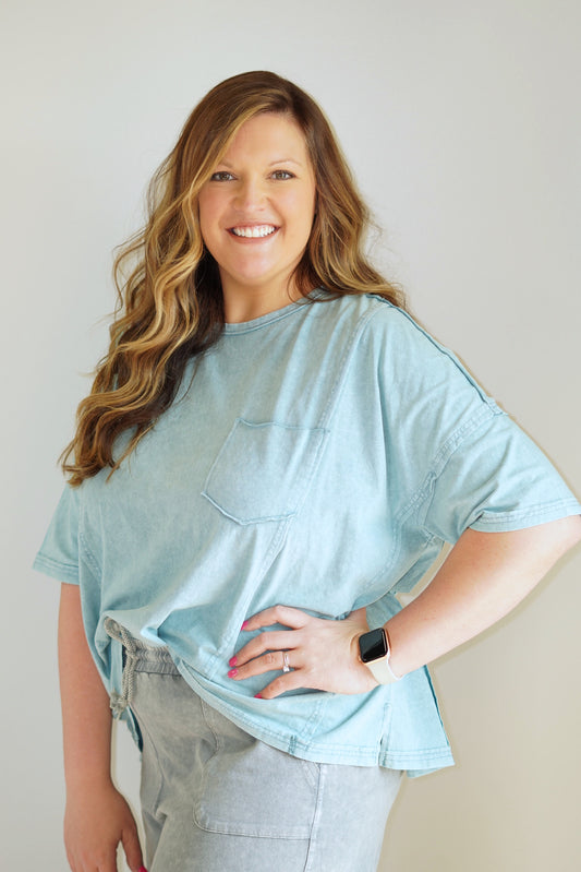 Lush Parker Pocket Tee Round Neckline Short Sleeve Front Pocket Raw Hem Detailing Faded Teal Color Full Length Loose Fit 100% Cotton Care: Hand Wash Cold, Hang to Dry, No Bleach Model is wearing size 1XL