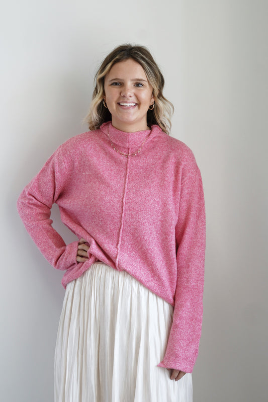 Mori Mock Neck Cozy Sweater Mock Neckline Long Sleeves Vertical Hem Line on Front Colors: Pink, Relaxed Fit Full Length 47% Polyester, 35% Acrylic, 15% Nylon, 3% Spandex