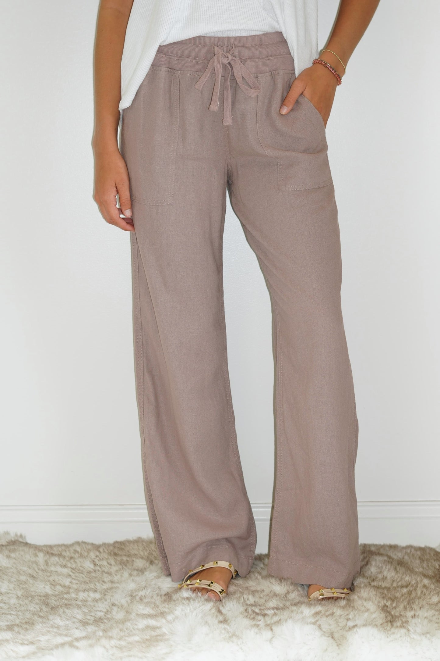 Sydney Linen Wide Leg Pant Rosey Brown Ribbed elastic waist band 63% polyester 33% Cotton 4% Spandex Turn inside out, Machine wash cold, tumble dry low, gentle cycle with colors, Do not bleach, hang to dry, Indigo will bleed, iron if needed Model is wearing size small