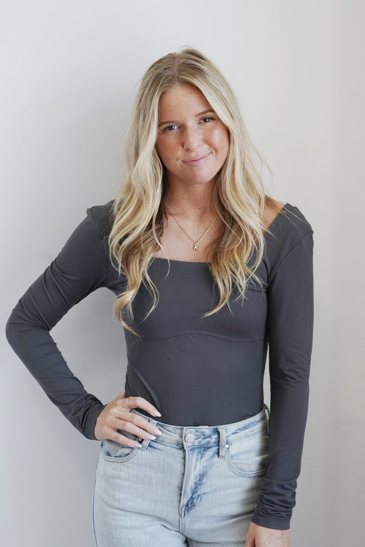 Sydney Sleek Square Neck Bodysuit Square Neckline Long Sleeves Thong Back Colors: Charcoal, V-Neck Backline Fitted Bodysuit 84% Polester, 16% Spandex