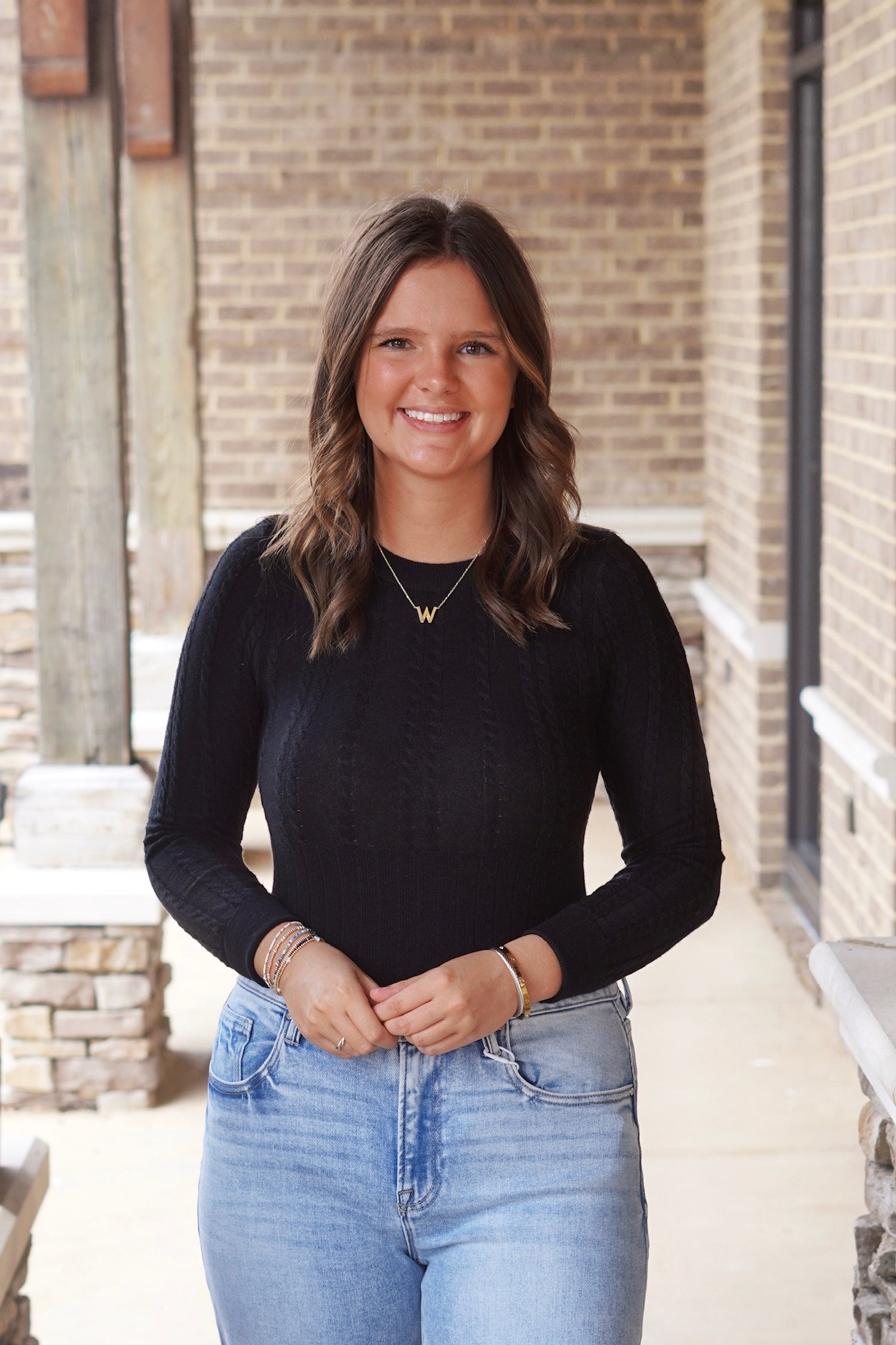 Woman wearing black fitted ribbed bodysuit paired with jeans