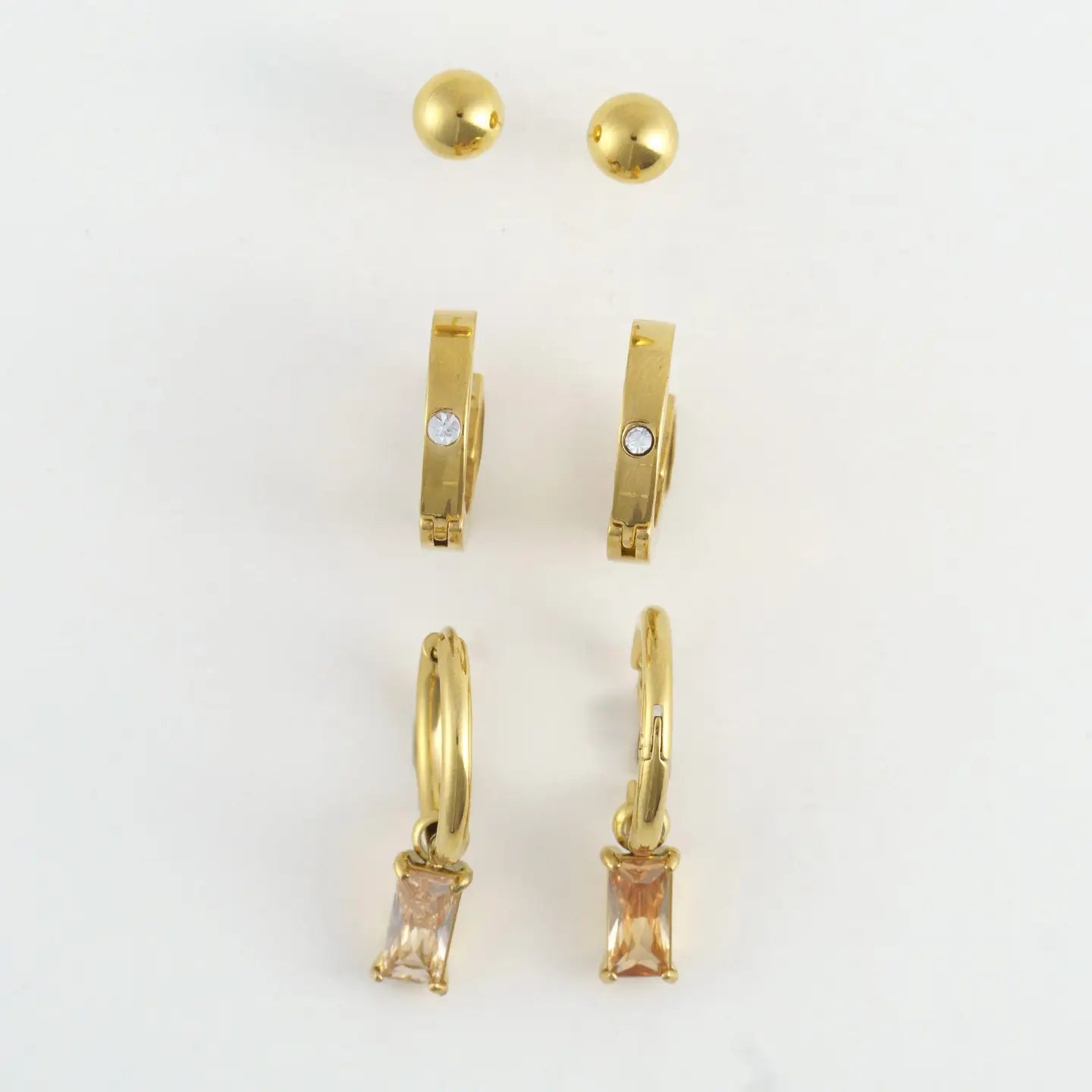 Gold earring trio, ball stud, gold hoop, and hoop with pink crystal pendant