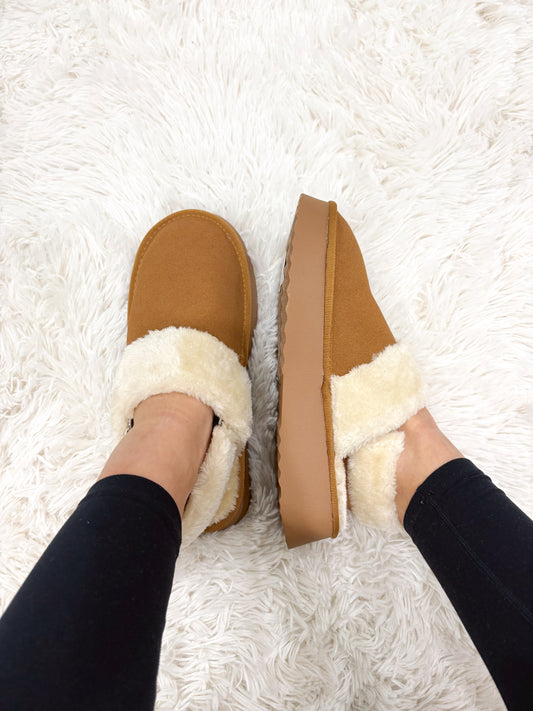 Tan suede platform slippers with a faux-fur lining. 