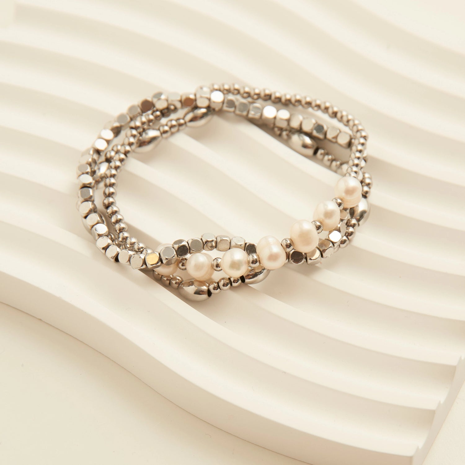 Genuine Pearl Ball Bracelet. This 3-piece stretch-fit stack features polished ball beads accented with luminous genuine pearls, offering a refined mix of texture and shine