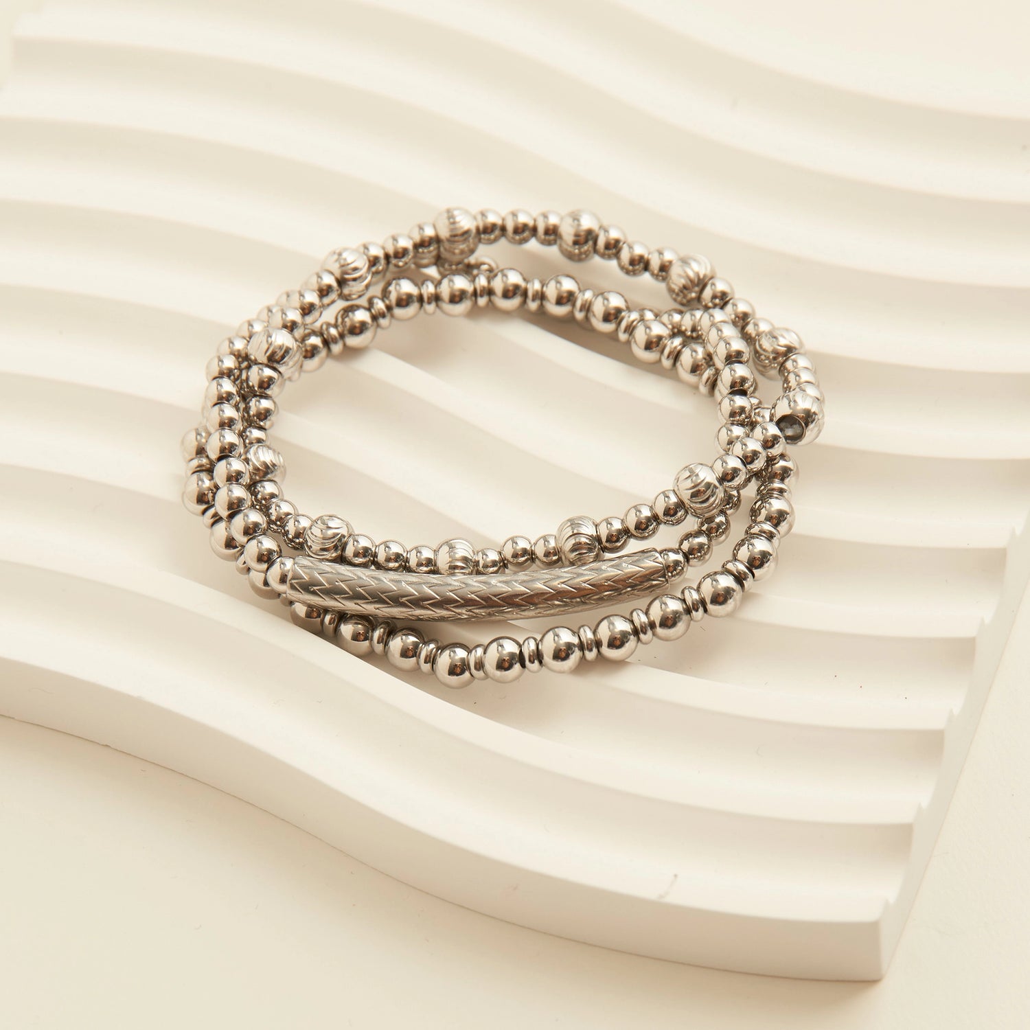 Sliver multi-strand bracelet with small, round beads and a textured central bar. 