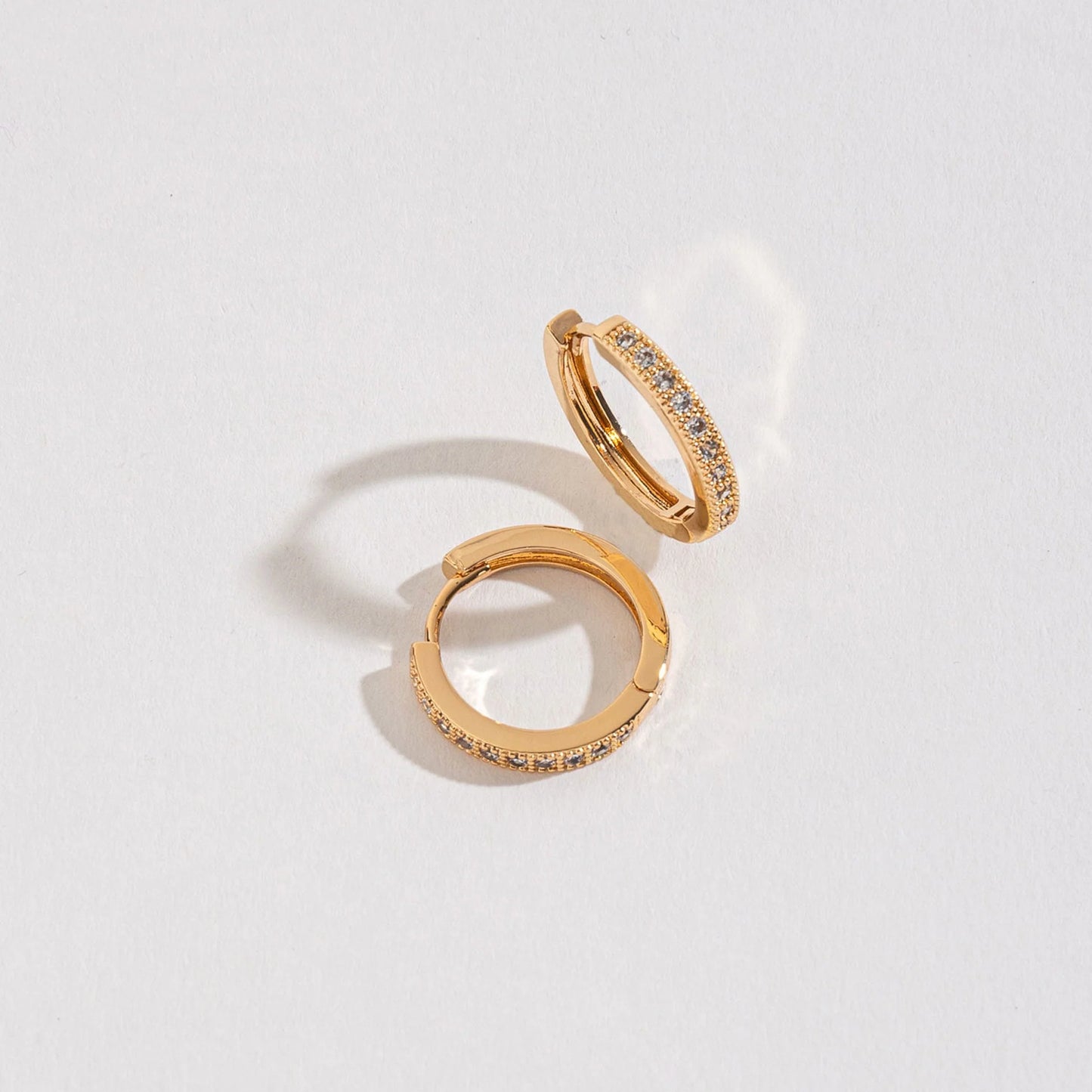 gold hoop earrings with crystals along the outer curve. 