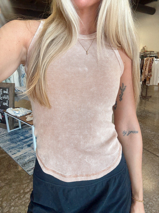 Women wearing a ribbed apricot tank, fitted style and a round neckline.  
