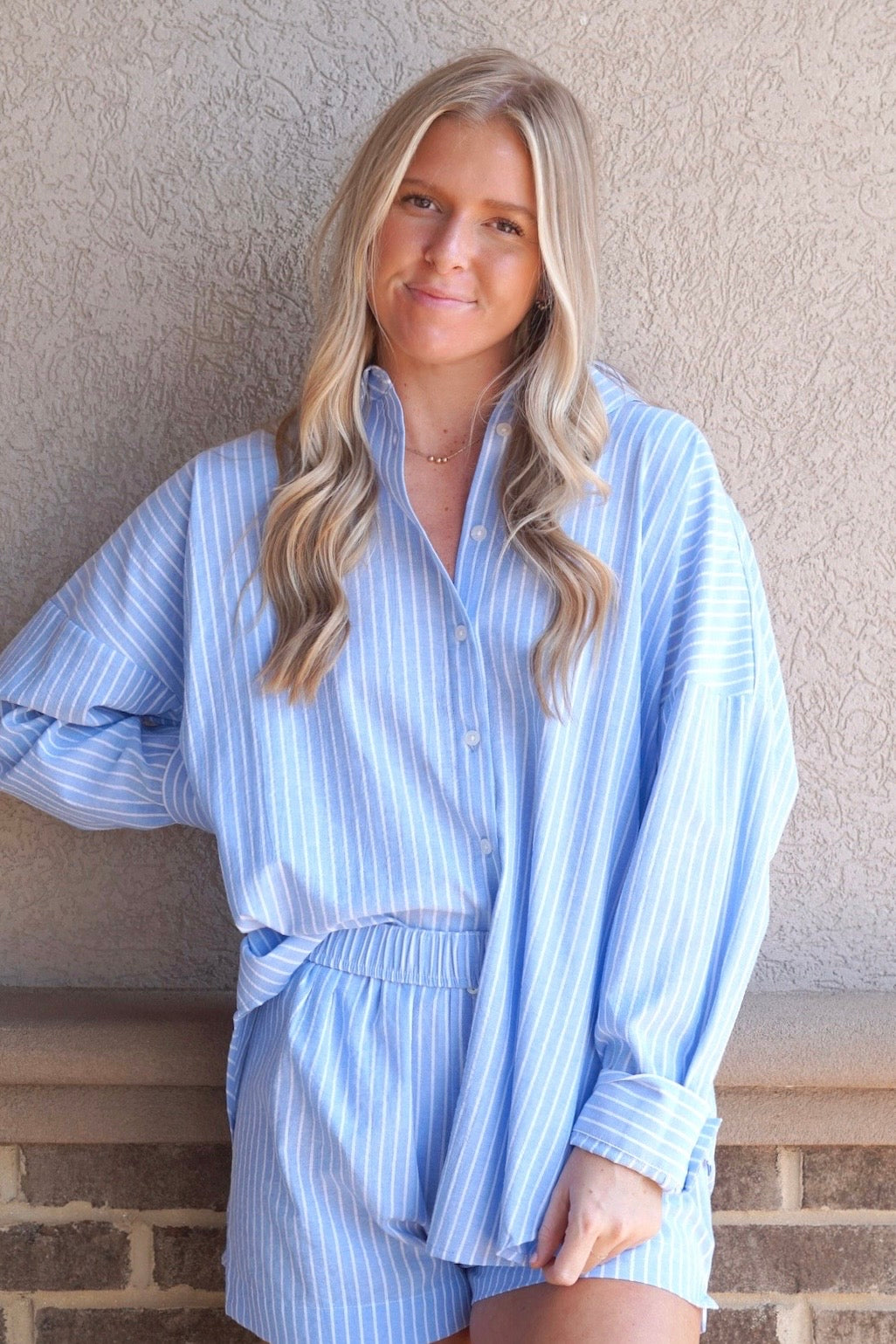 Light blue with white stripes blouse. Collared neck, button down. Cuffed sleeve. Long sleeves 