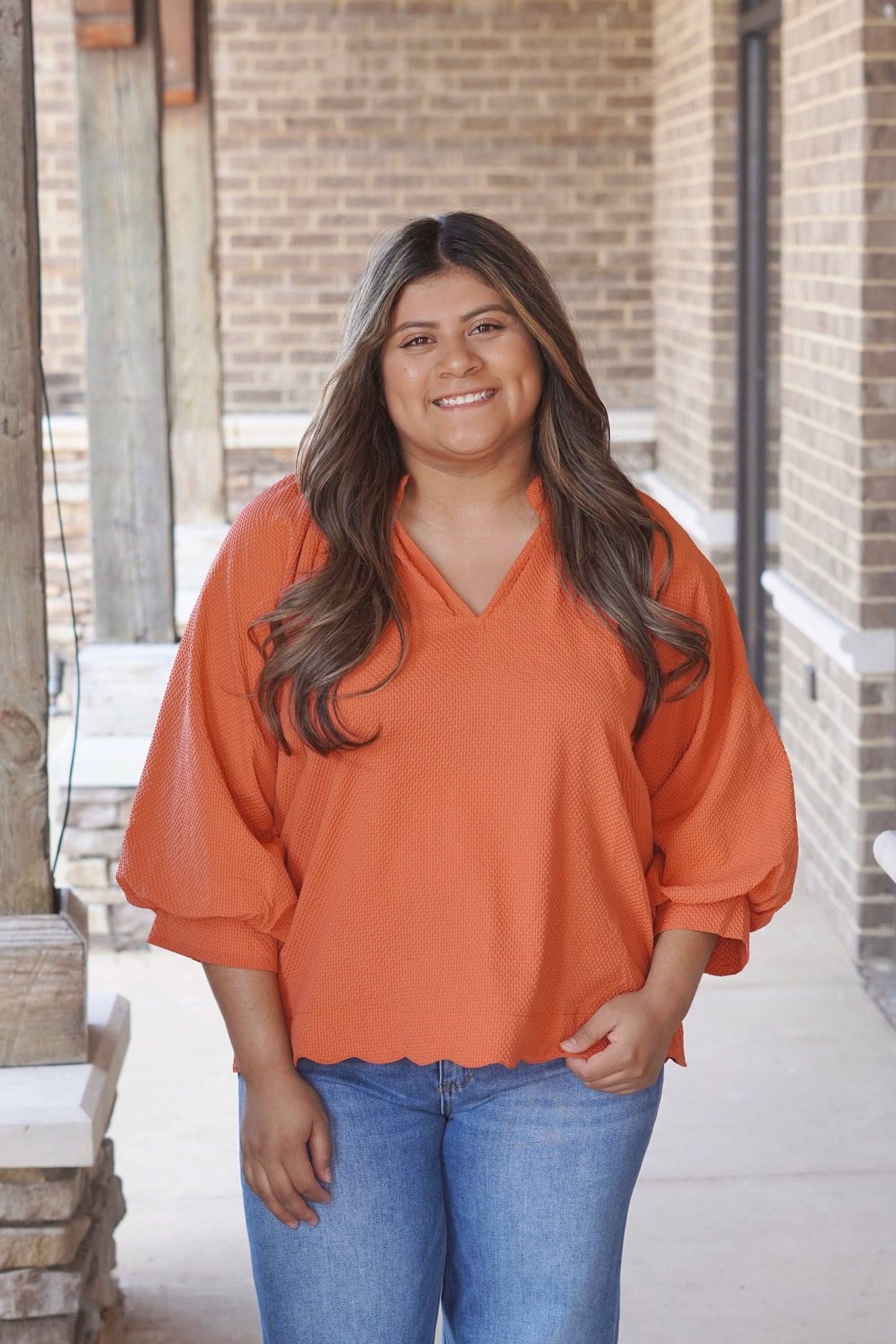 Tilly Textured V-Neck Blouse, V-Neckline, Quarter Length Sleeves, Textured Material, Scalloped Hemline, Relaxed Fit, Full Length, Color: Rust Orange. 