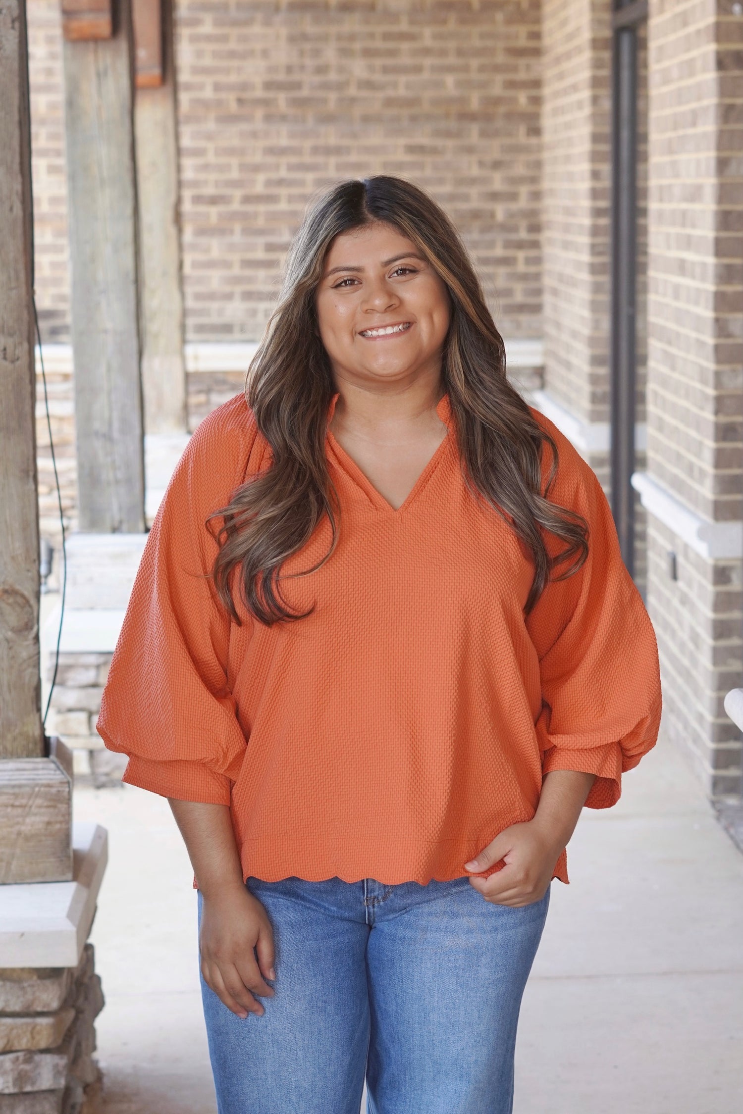 Tilly Textured V-Neck Blouse, V-Neckline, Quarter Length Sleeves, Textured Material, Scalloped Hemline, Relaxed Fit, Full Length, Color: Rust Orange. 