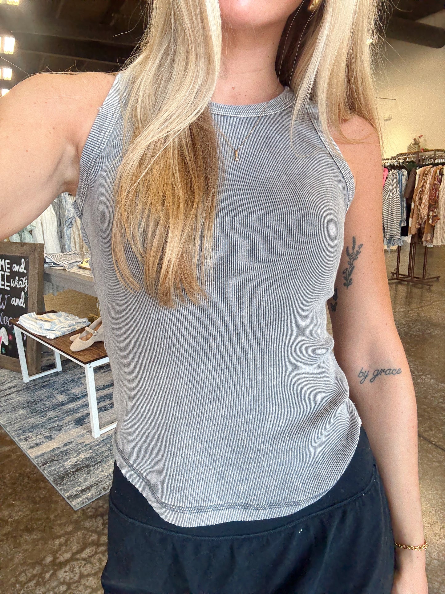 Women wearing a ribbed ash grey tank, fitted style and a round neckline.  