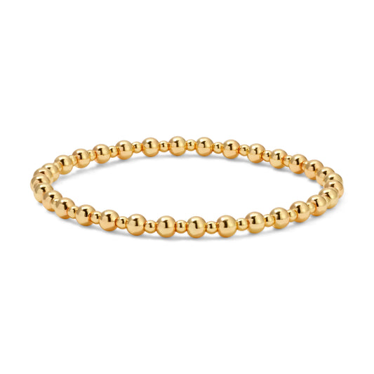 Gold beaded bracelet on a white background