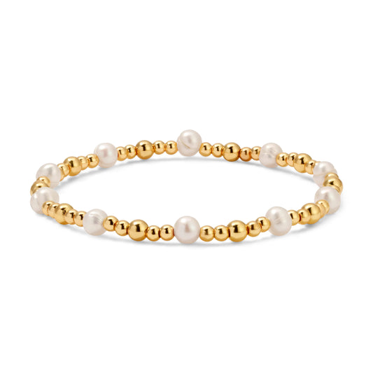 Bracelet with gold beads and pearls on a white background