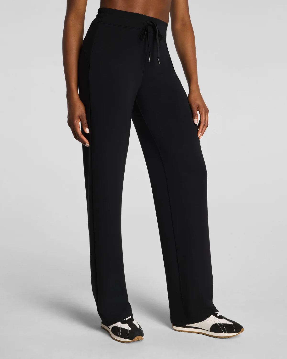 Person wearing a Black Straight leg pants with a drawstring 