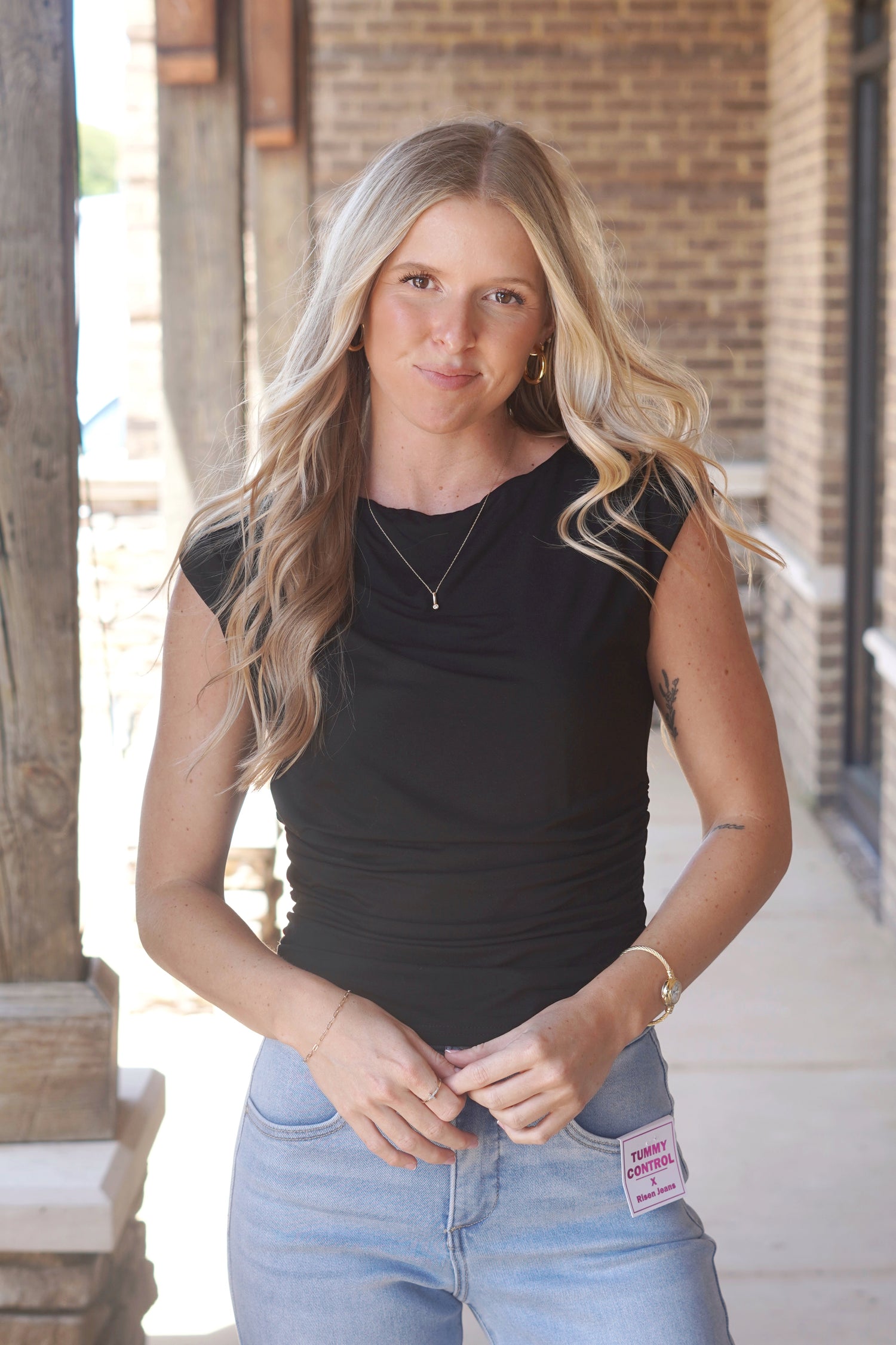 Women wearing a Black top with a 
Round Neckline and a Cinched Waist, Short sleeve. 