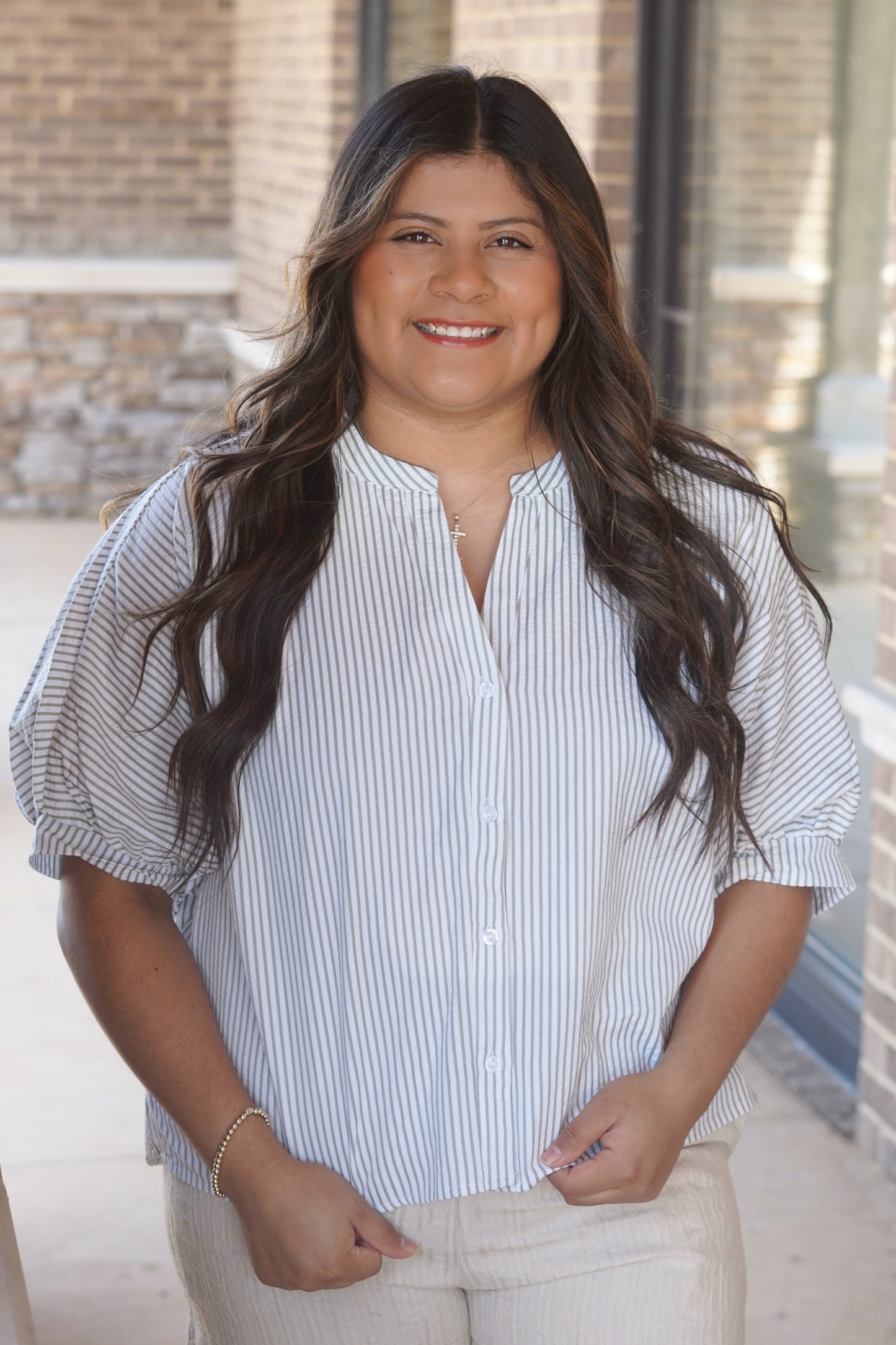 Women wearing a stripe button down, puff sleeve, round v-neckline top. 