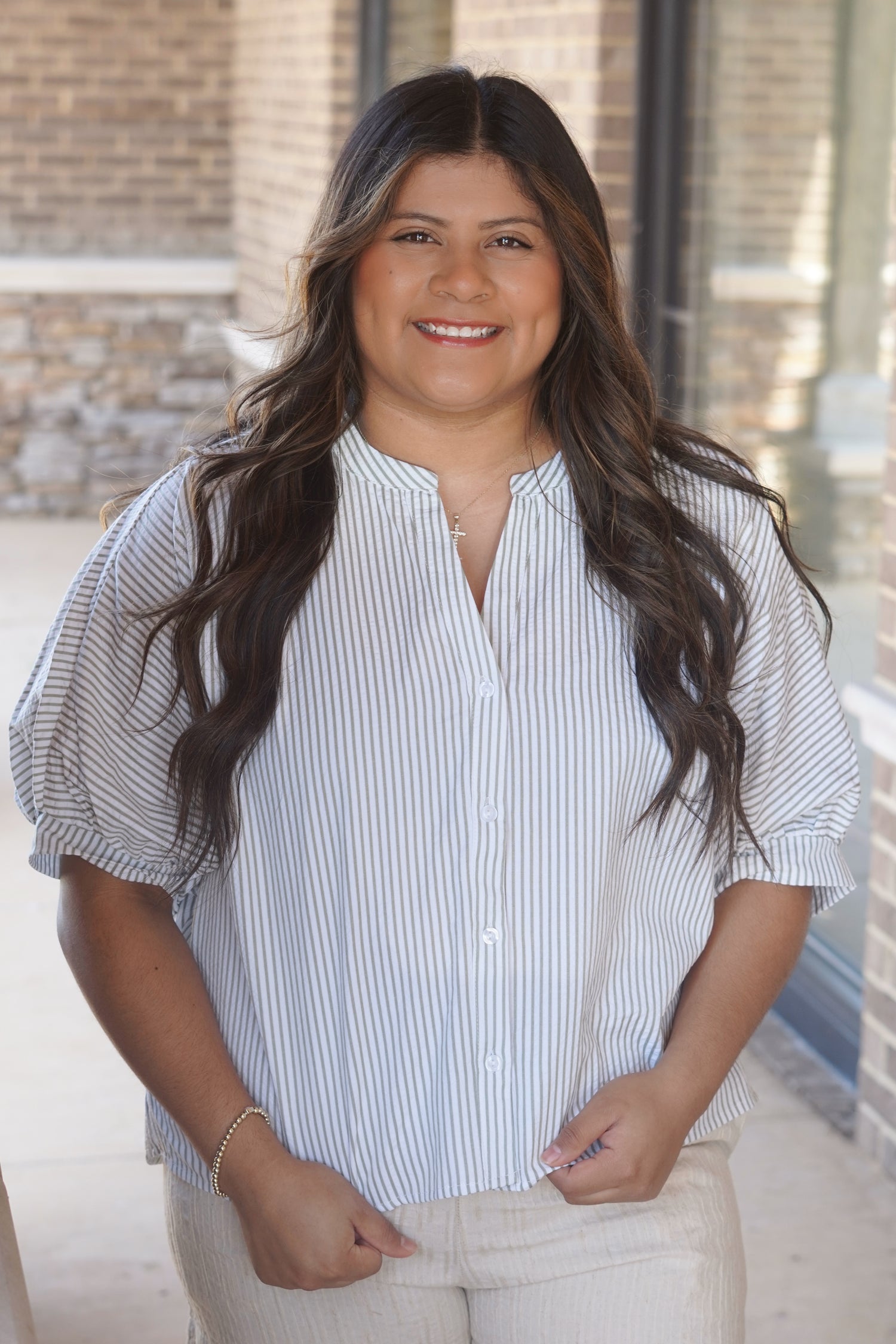 Women wearing a stripe button down, puff sleeve, round v-neckline top. 