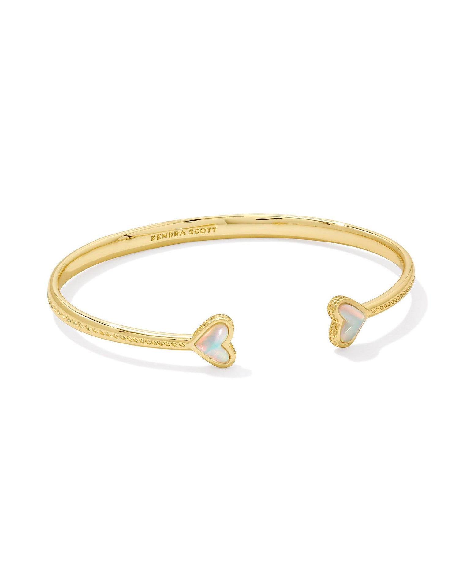 gold cuff bracelet with two hearts with white opalescent stoned centers