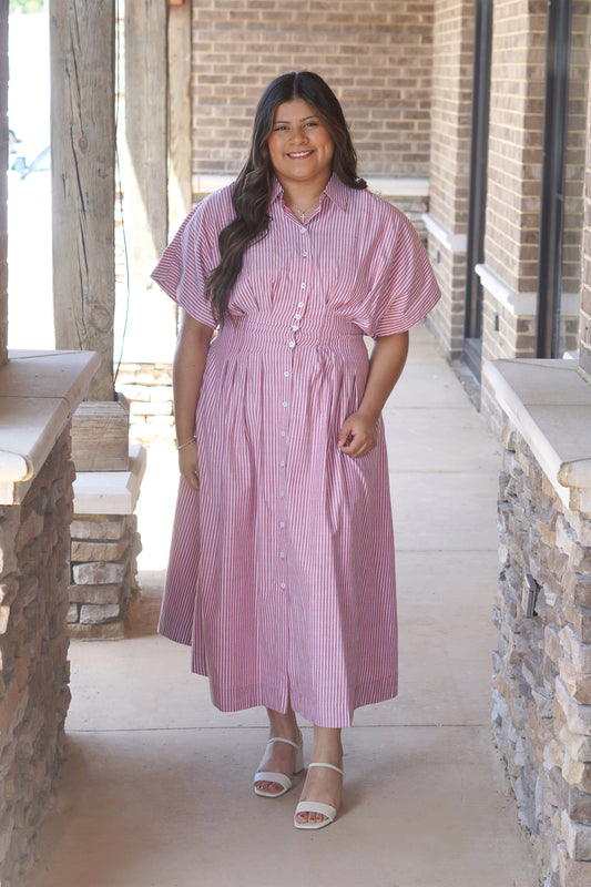 Women wearing a maxi red striped dress, buttons going down the middle, collar neckline, short sleeve.