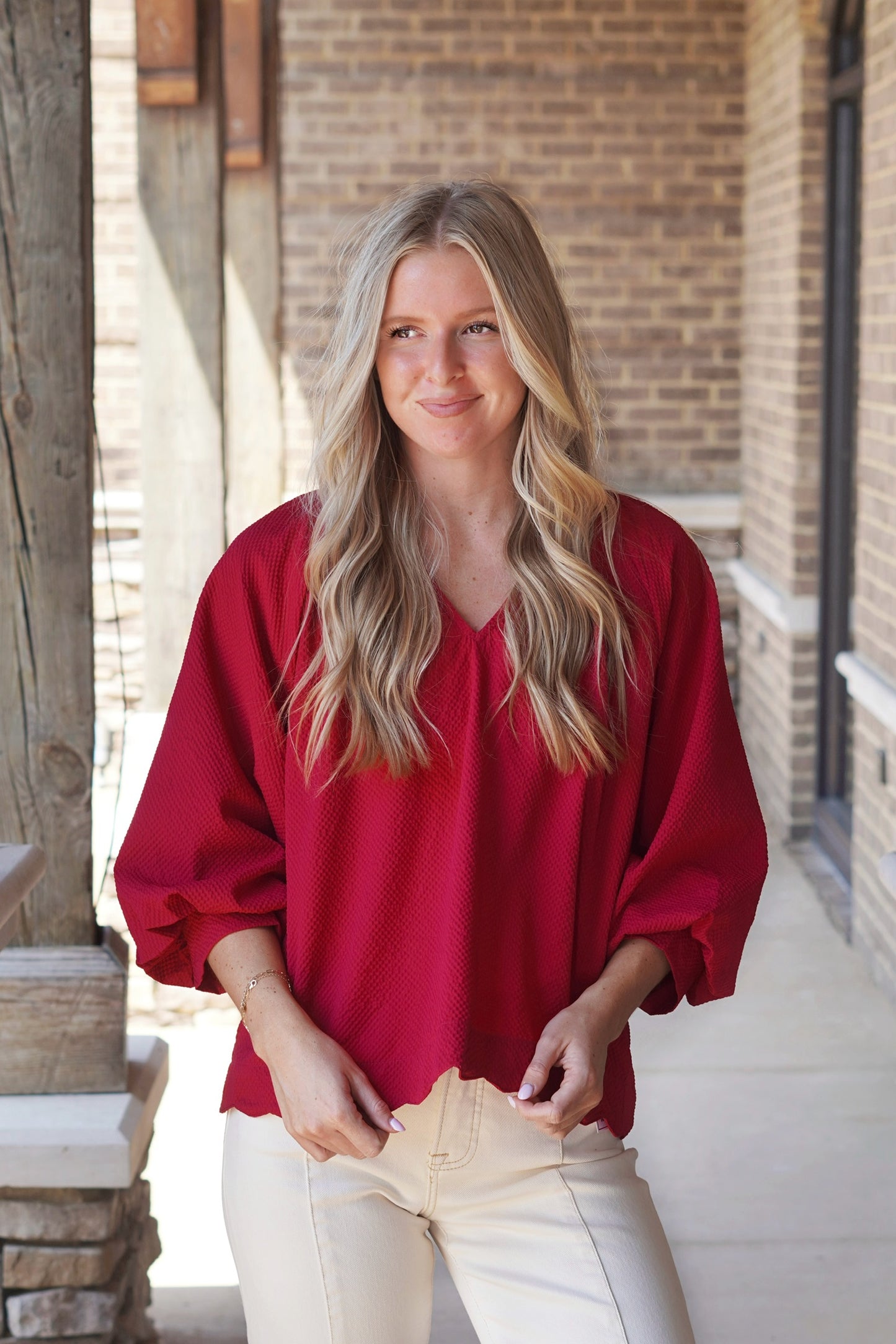 Tilly Textured V-Neck Blouse, V-Neckline, Quarter Length Sleeves, Textured Material, Scalloped Hemline, Relaxed Fit, Full Length, Color: Crimson. 
