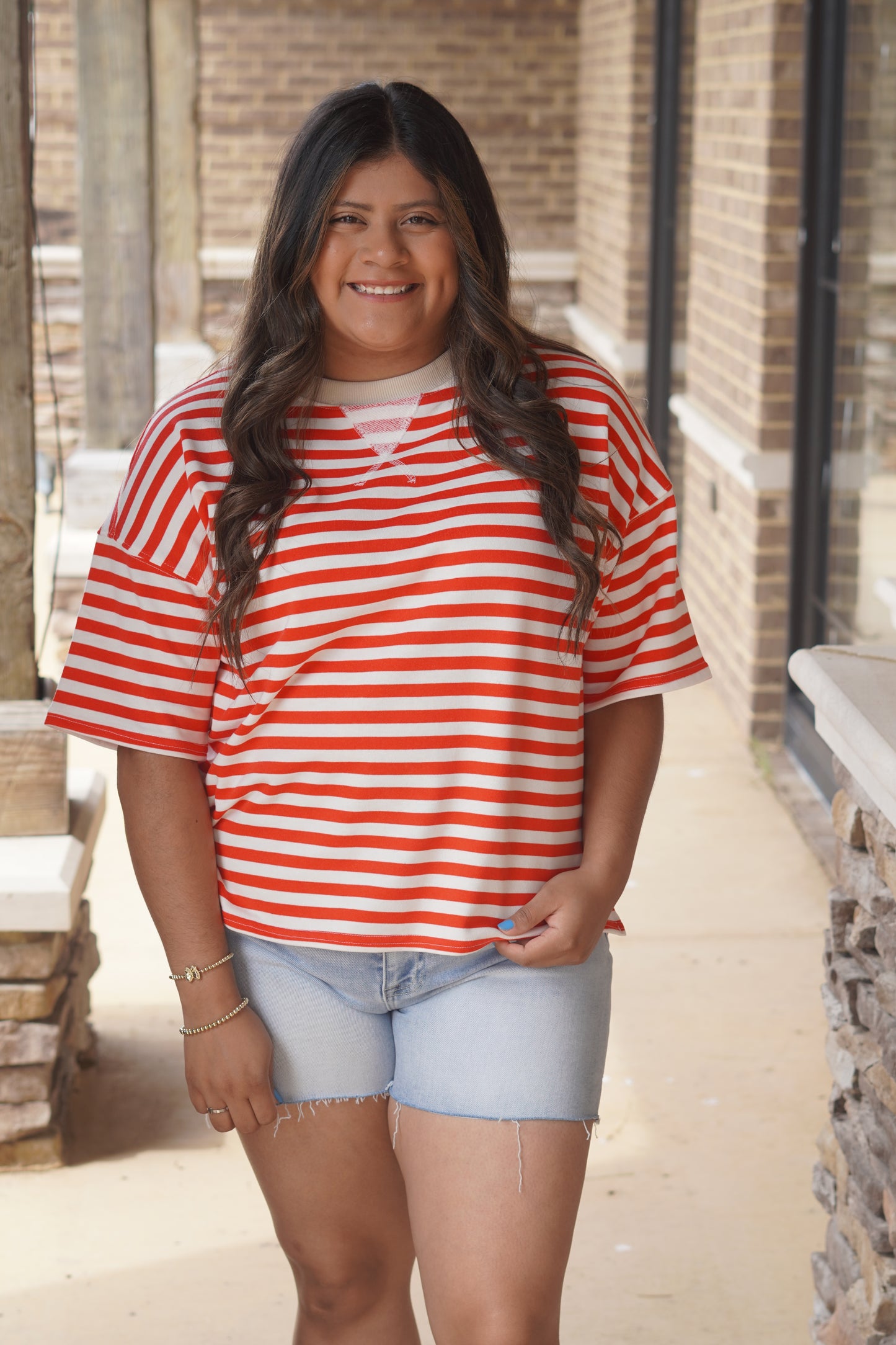 Women wearing a red stripped top with a cream neckline. 