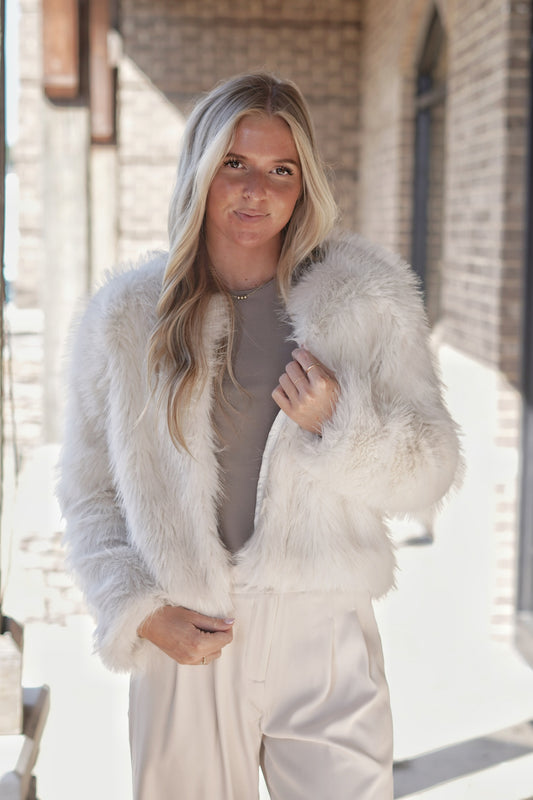 Elevate your style with this elegant dressy fur jacket, designed for those special occasions. Crafted from sumptuous faux fur, it features a tailored silhouette that flatters any figure. The luxurious texture adds a touch of sophistication, while subtle embellishments. Perfect for layering over evening wear, this jacket ensures you stay warm without compromising on elegance. White