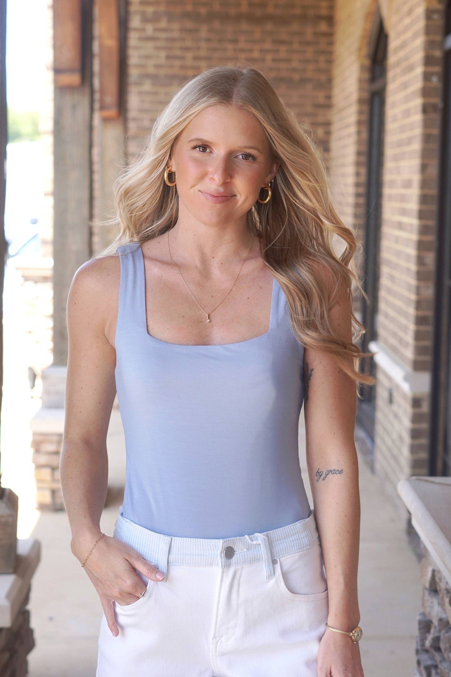 Women wearing a blue square neck bodysuit tank. 