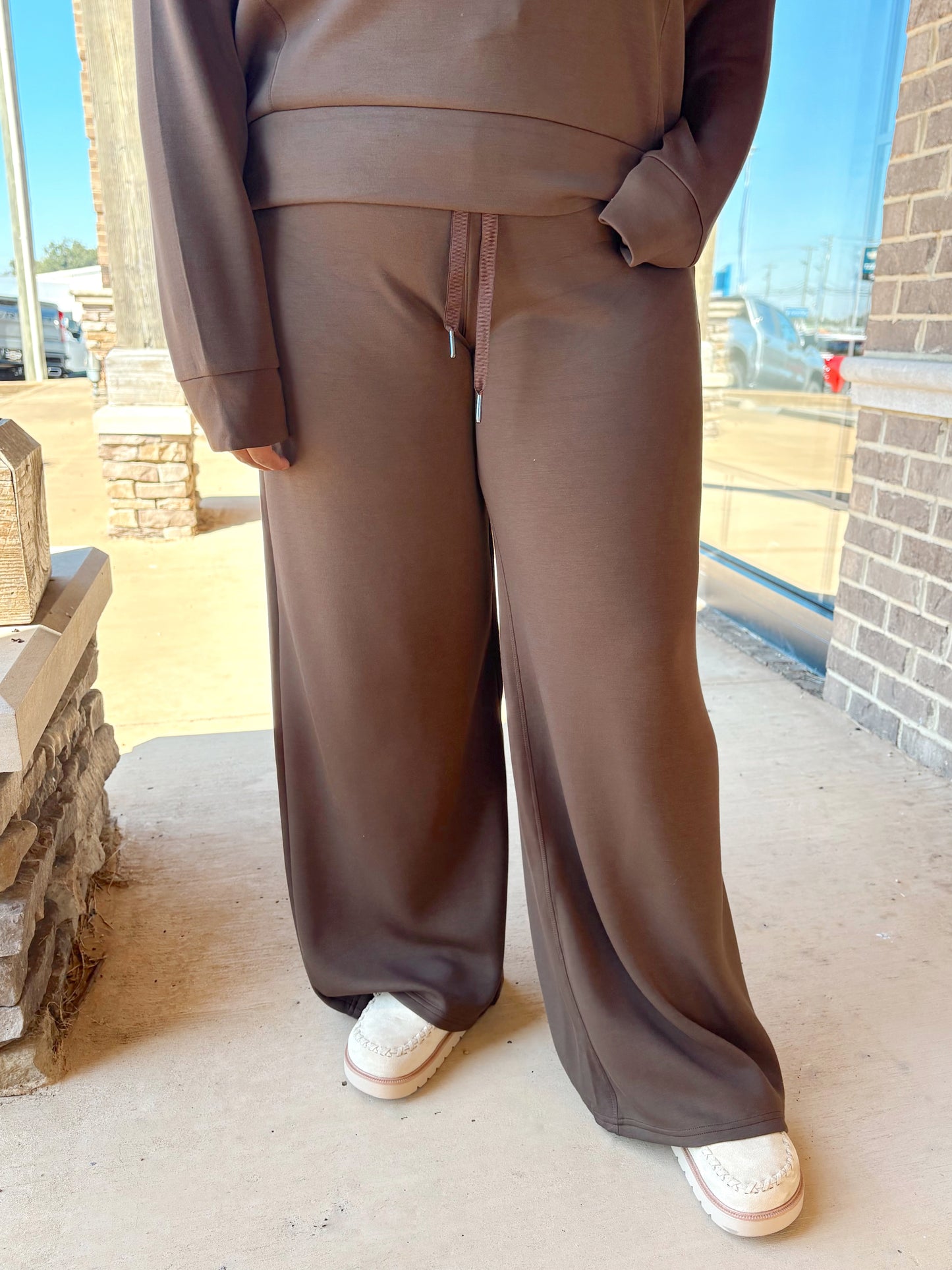 A person wearing a brown lounge wide-leg pants