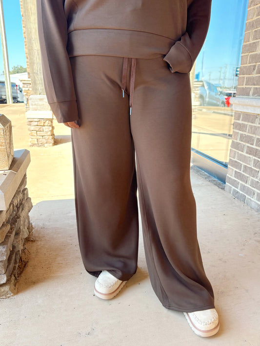 A person wearing a brown lounge wide-leg pants