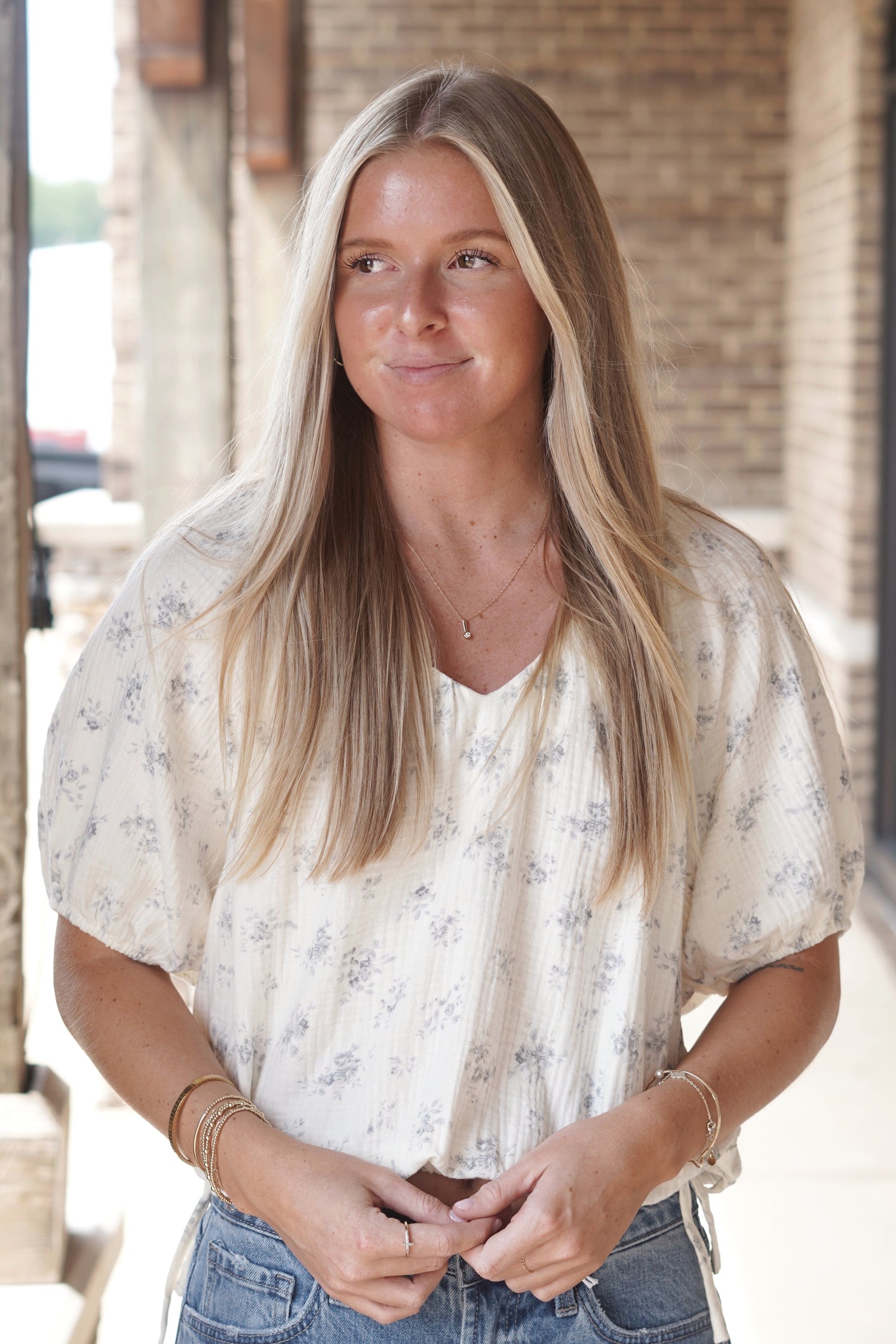 Cream top. Light blue small floral print. Functional ties at bottom of the shirt. Short sleeves. V neckline