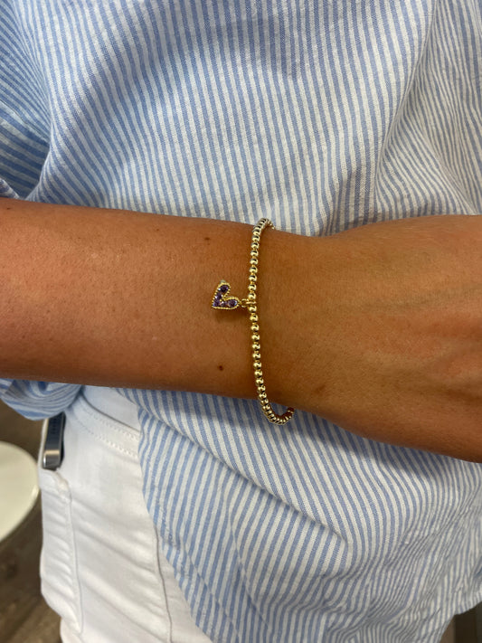 Gold beaded bracelet with a heart charm beaded with purple stones.