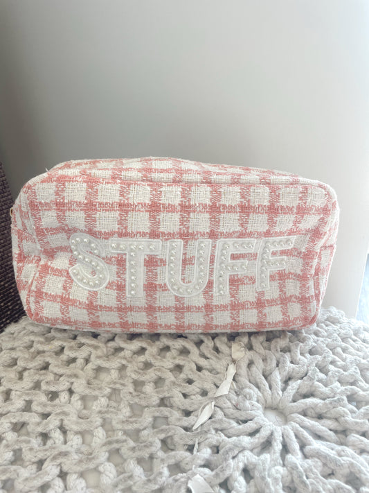 pink tweed accessory bag that says "stuff" in pearll studded block letters