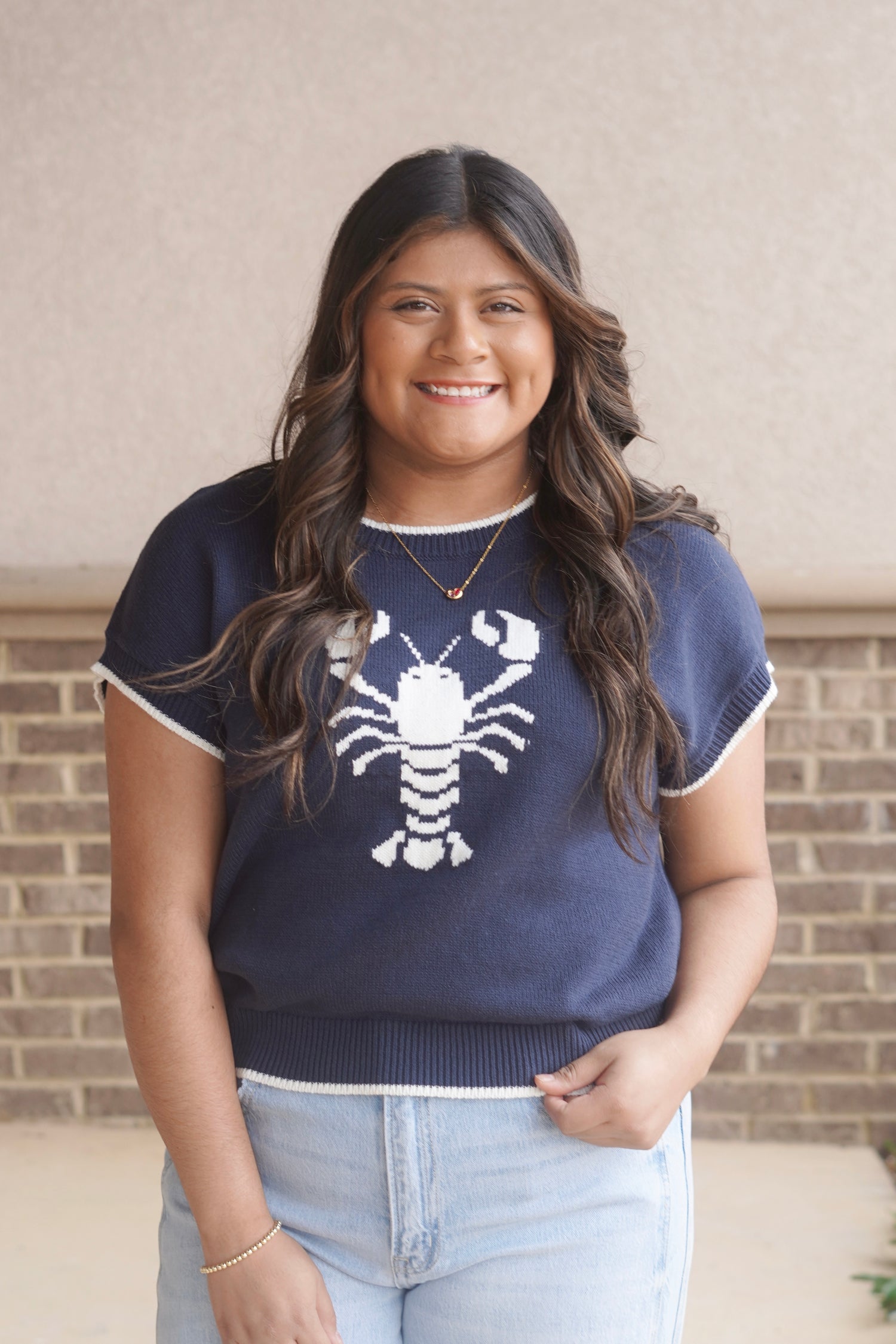 women wearing a navy knit top with a white lobster in the center and white trim, round neckline, short sleeve.