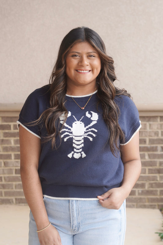 women wearing a navy knit top with a white lobster in the center and white trim, round neckline, short sleeve.
