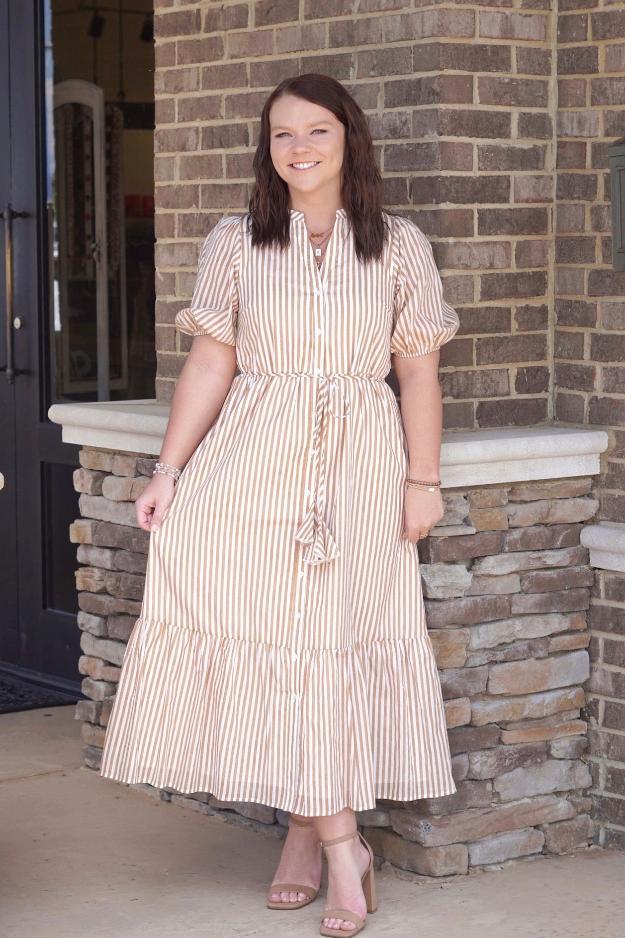 taupe and white button down striped dress, v-neckline, midi length, cuffed short sleeve, drawstring that snitches at the waist, one tiered. 