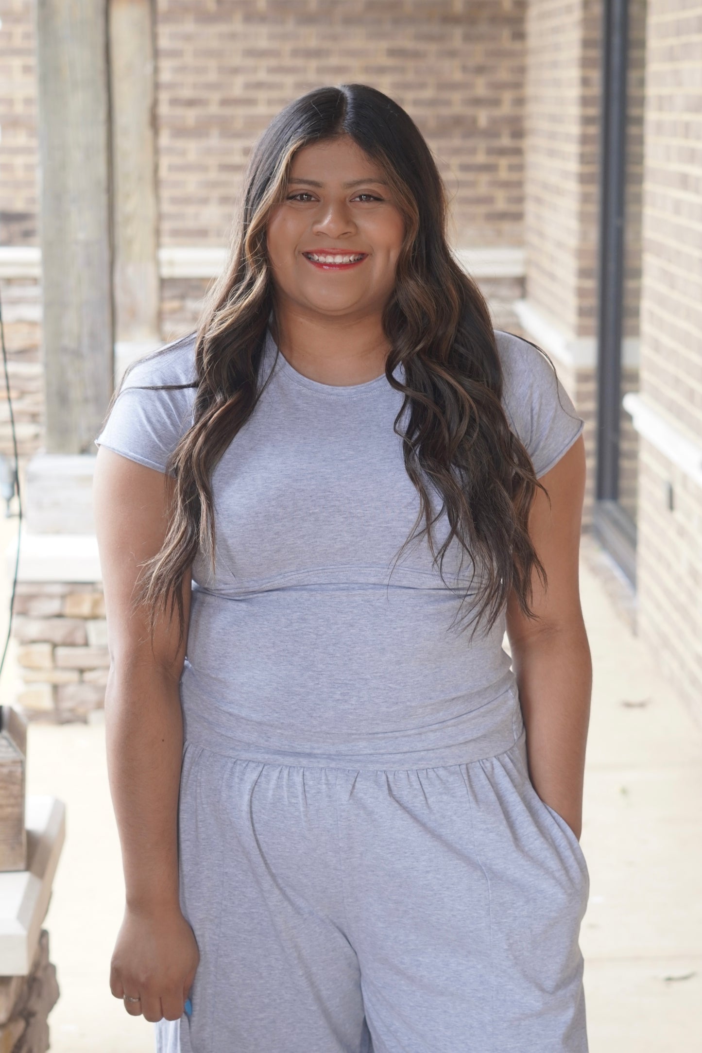 women wearing a heather grey fitted top with and a round neckline. 
