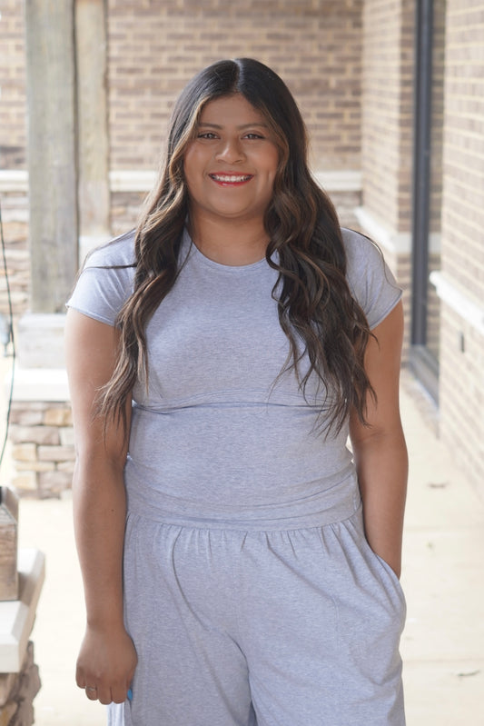 women wearing a heather grey fitted top with and a round neckline. 