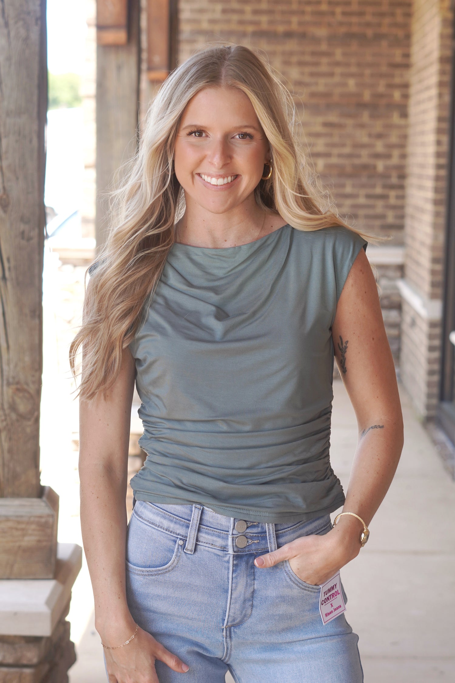 Women wearing a green top with a 
Round Neckline and a Cinched Waist, Cap Short sleeve. 
