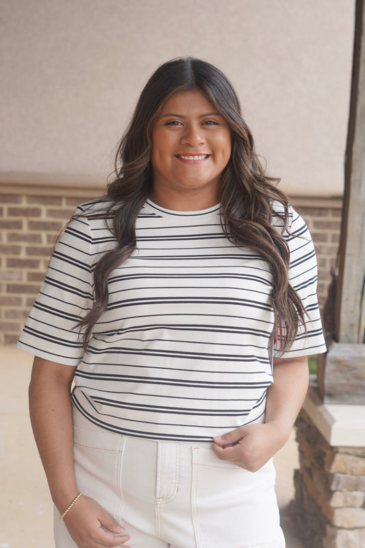 Women wearing a white with black short sleeve t shirt, round neckline, ribbed material. 