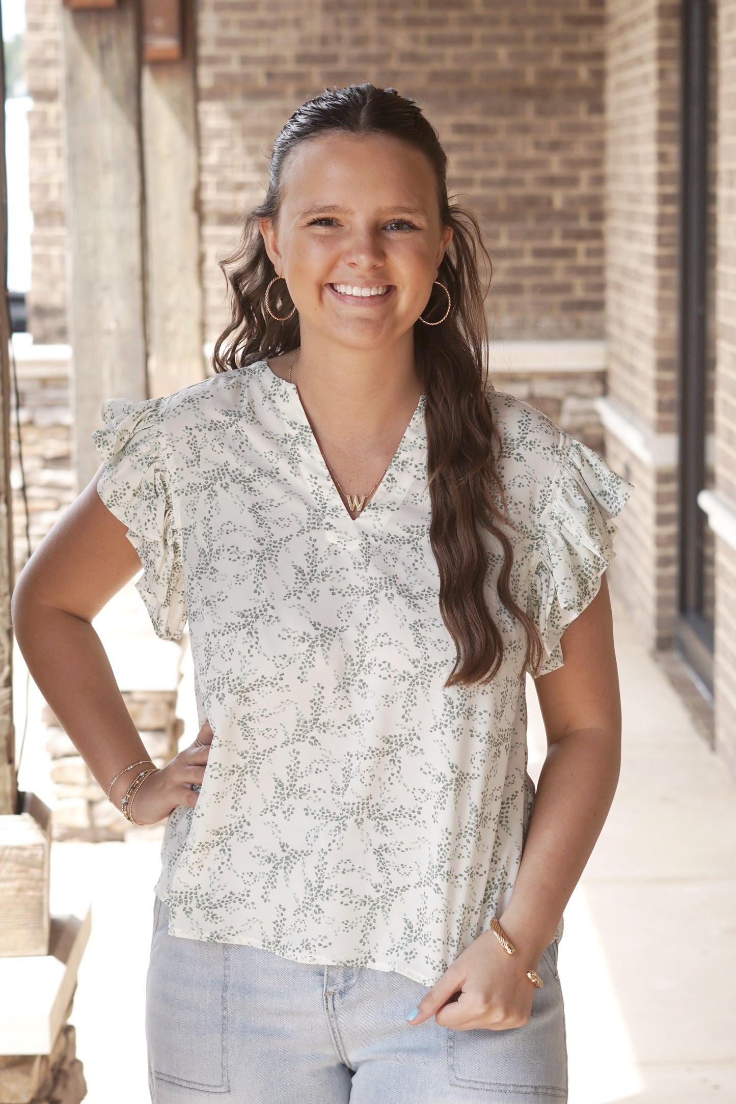 Cream and light green leaf printed top. Ruffled short sleeves. V neckline