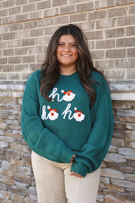 Dark green knit "ho ho ho" sweater with santa faces as the "O" in "ho" 