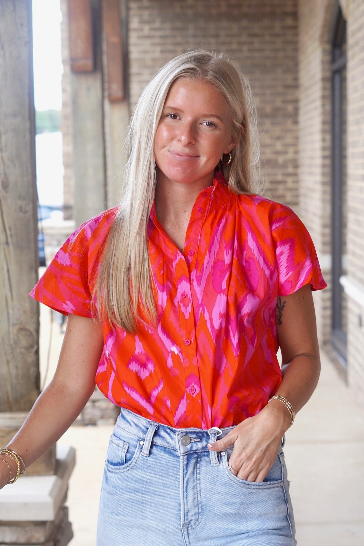 short sleeve mock neck top, relaxed fit, vibrant pink and purple colored, button up