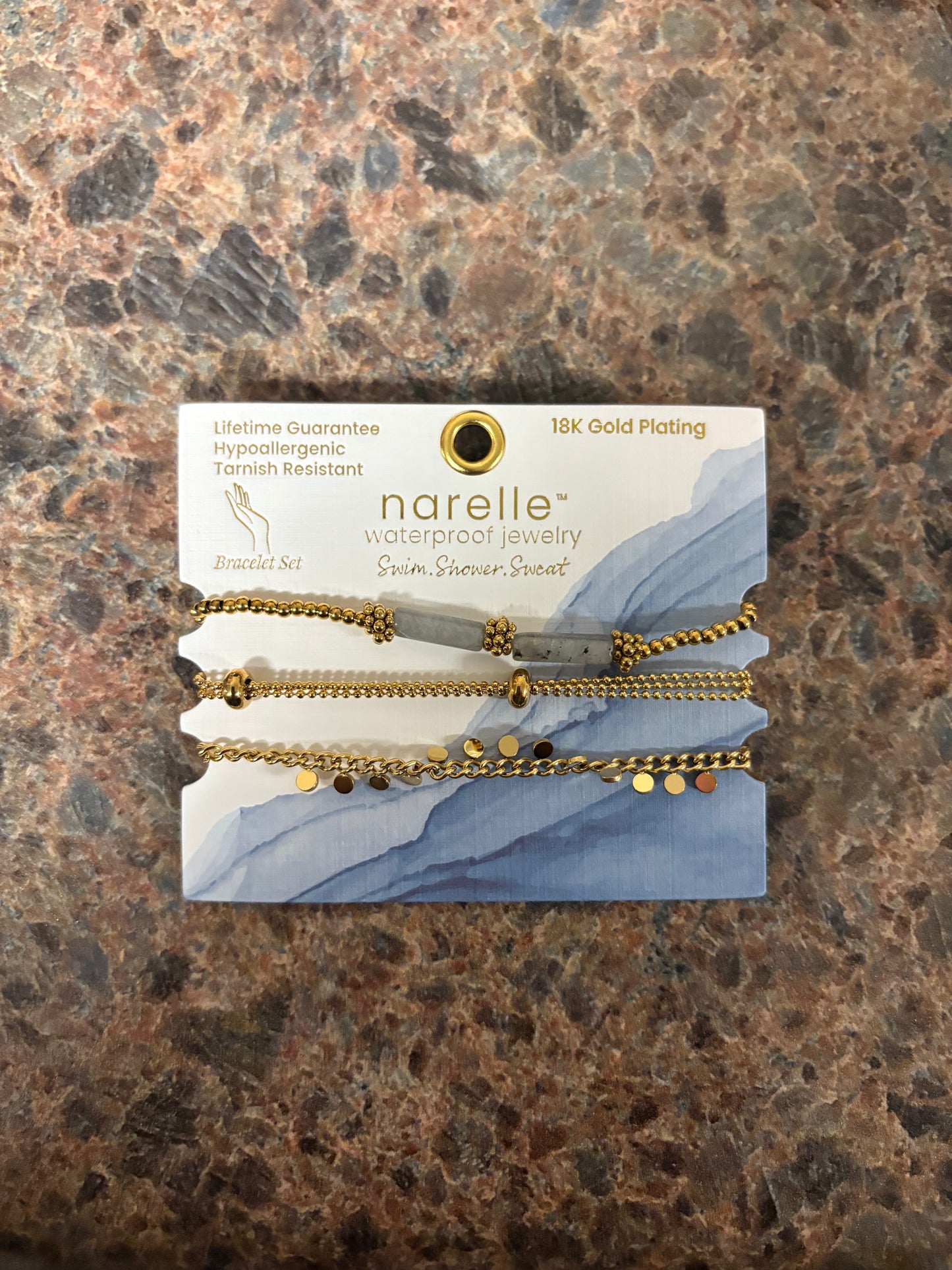 Narelle bracelet set on a branded card with gold chains with gray and gold charms and beads
