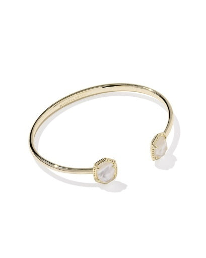 Gold open cuff bracelet with ivory stone at the end in a gold texture frame. 