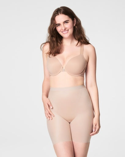 Model wearing Light Beige Spanx Spandex Shorts; Mid-thigh Length; Includes Tummy Control Technology